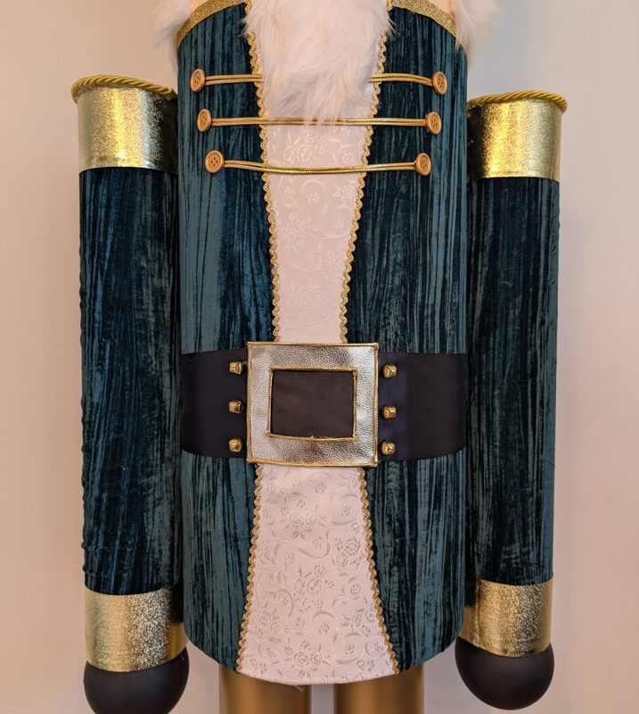 Close-up of the teal velvet coat, gold braid, epaulettes and belt buckle